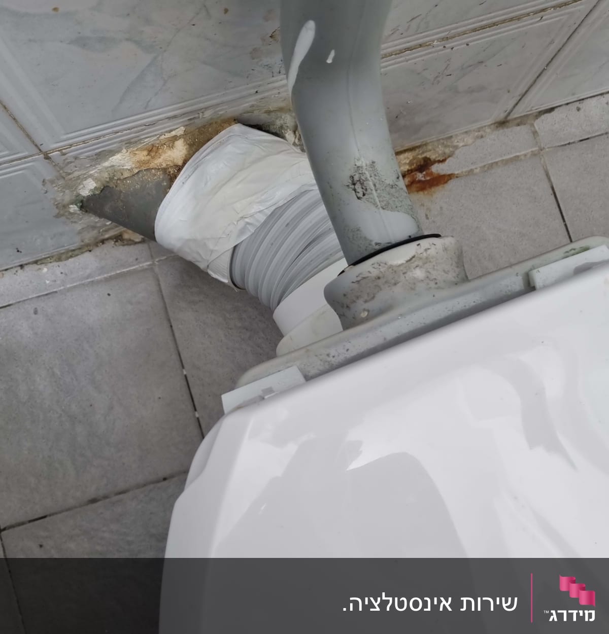 צינור אפור מחובר לאסלה עם חיבור לבן